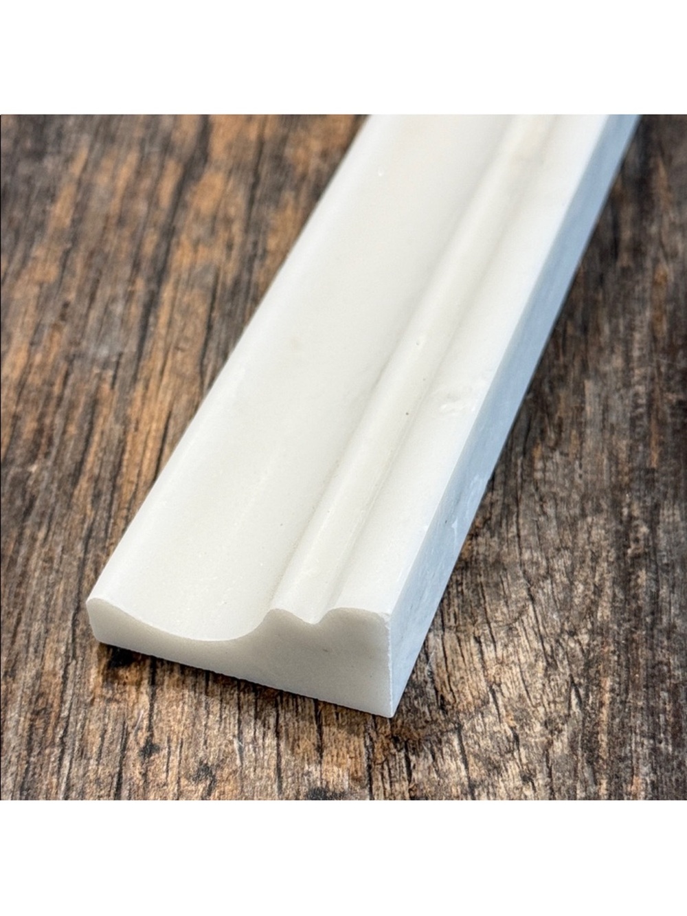Pearl white 2”x 12” honed capital marble molding.